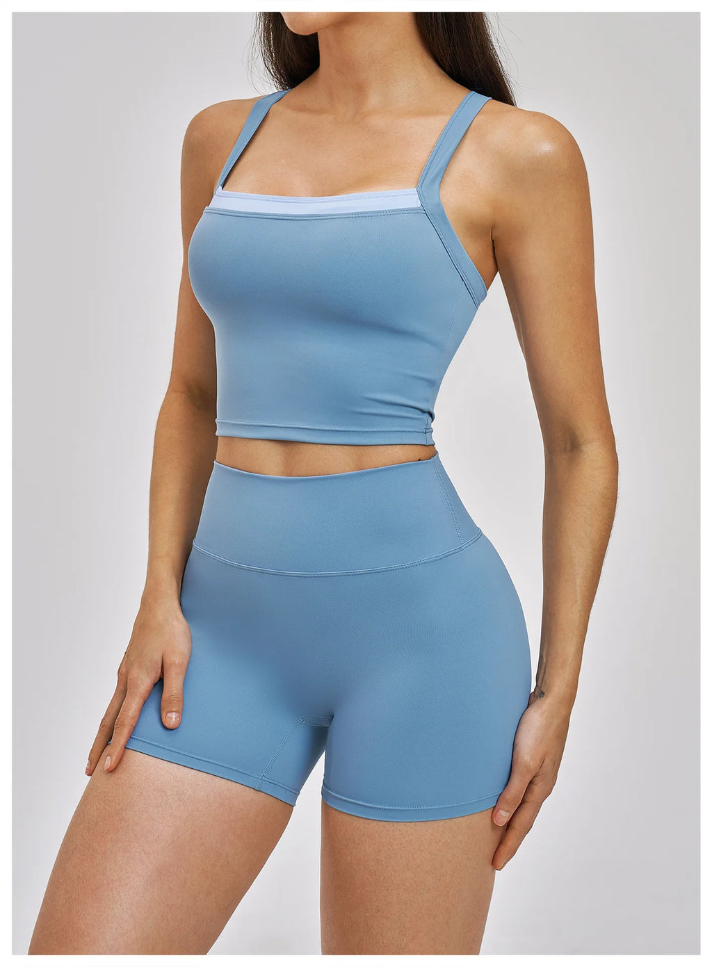 Woman wearing a blue athletic outfit on a plain background