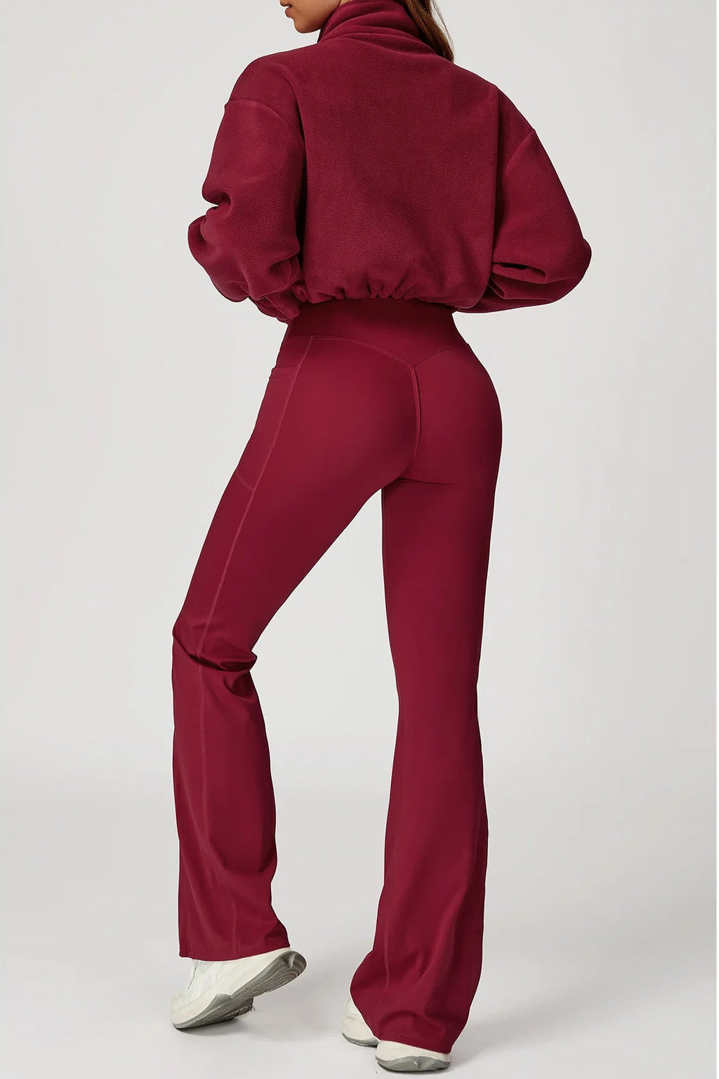 Maroon tracksuit worn by a person on a white background