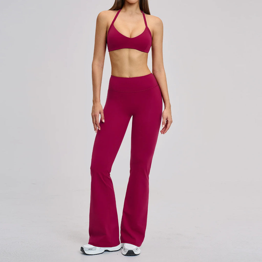 Person wearing a magenta sports bra and leggings set on a gray background