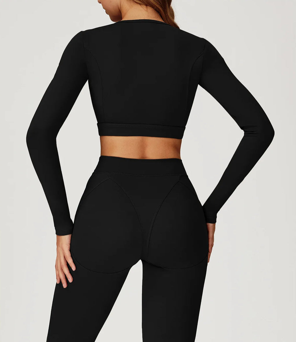 Black long-sleeve crop top and leggings on a plain background