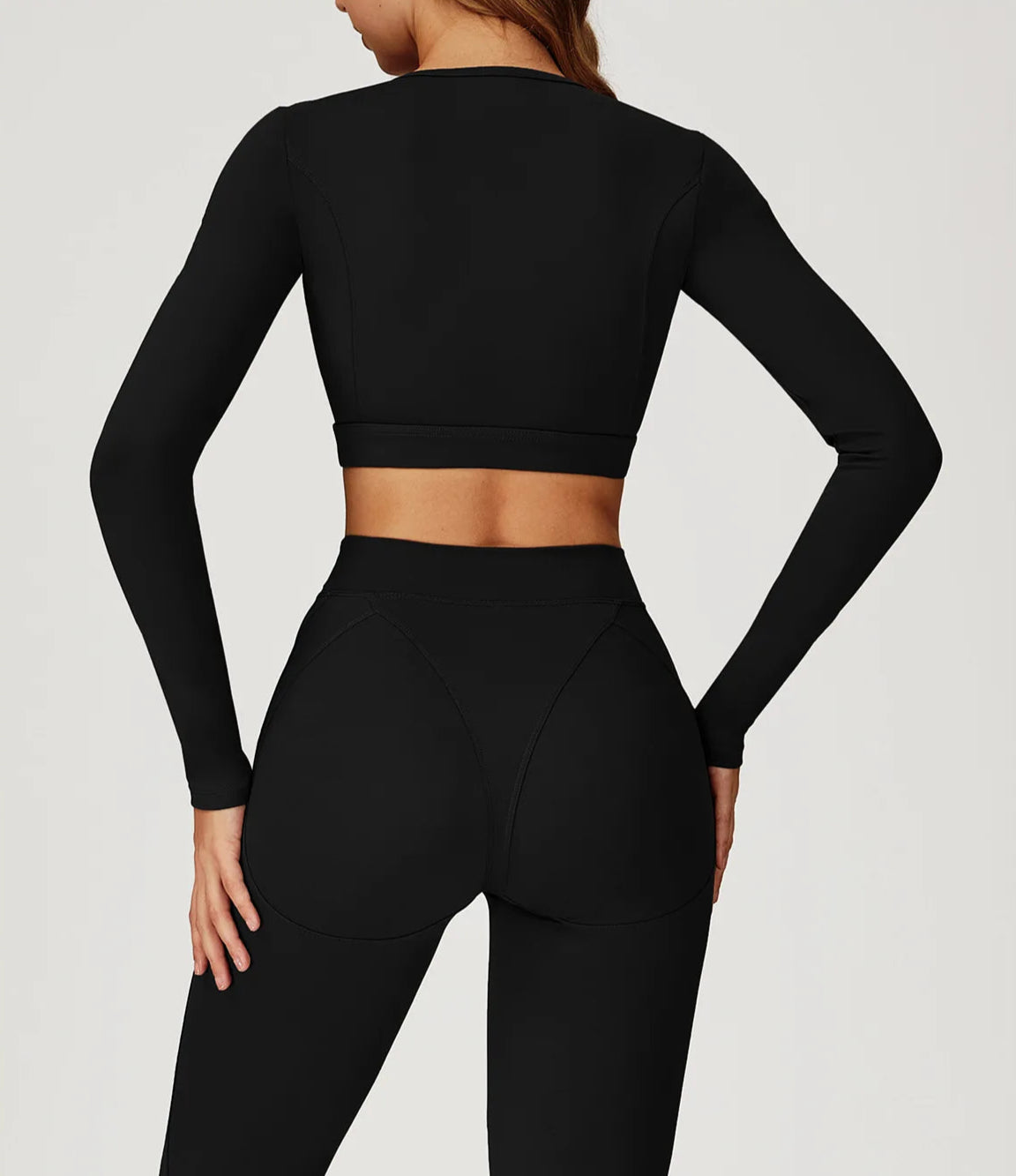 Black long-sleeve crop top and leggings on a plain background