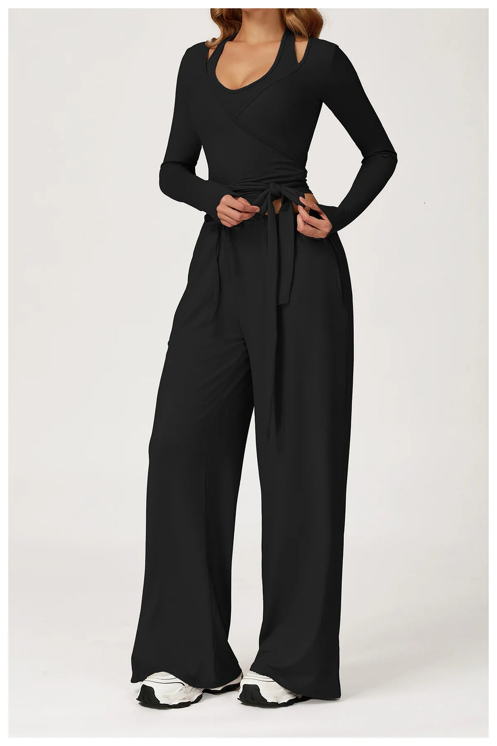 Black ballet wrap top and wide-leg pants worn by a person on a white background