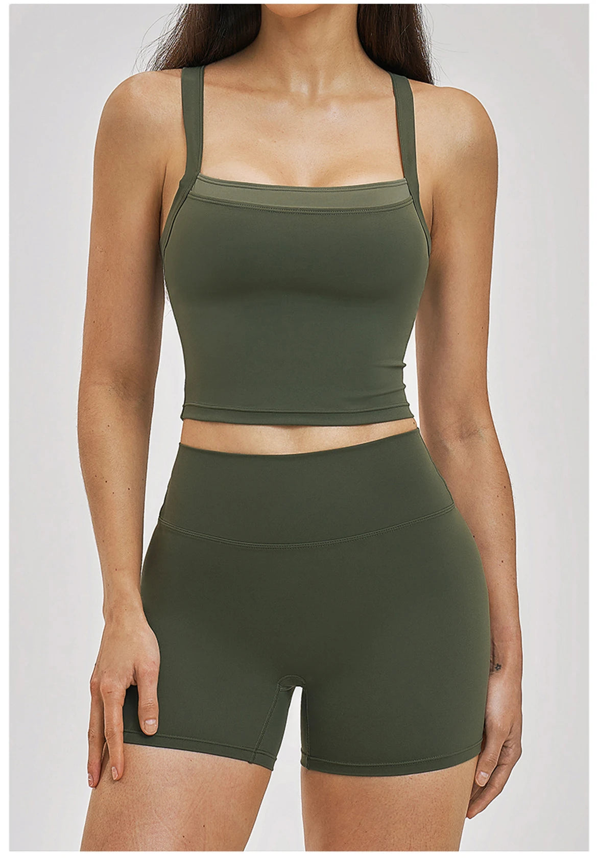 Person wearing a green sports bra and shorts set on a white background