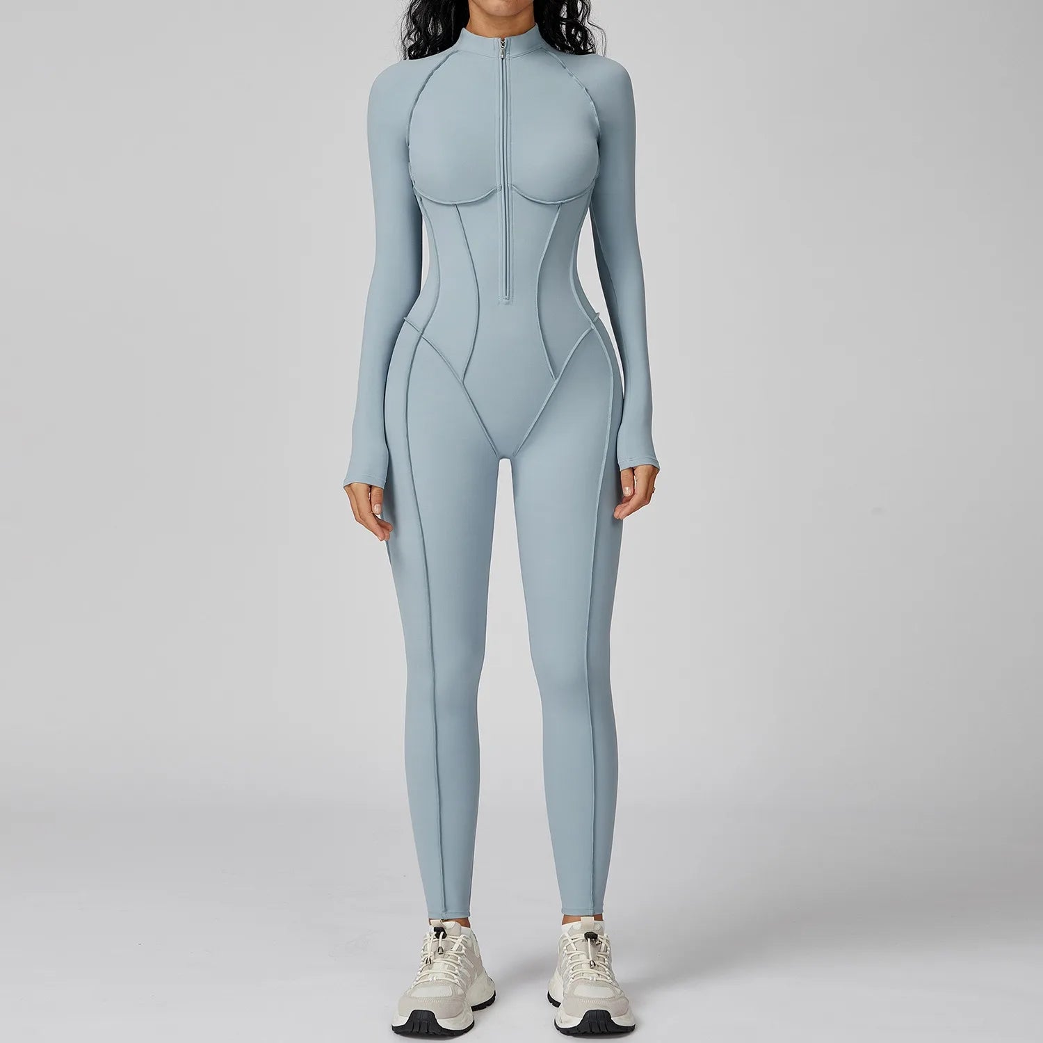 Person wearing a light blue bodysuit on a gray background