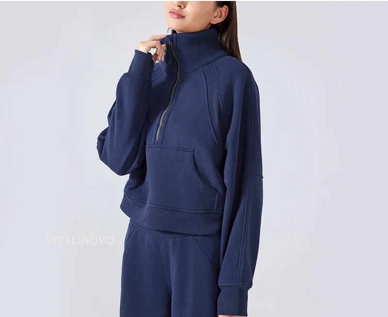 Person wearing a navy blue tracksuit against a light gray background