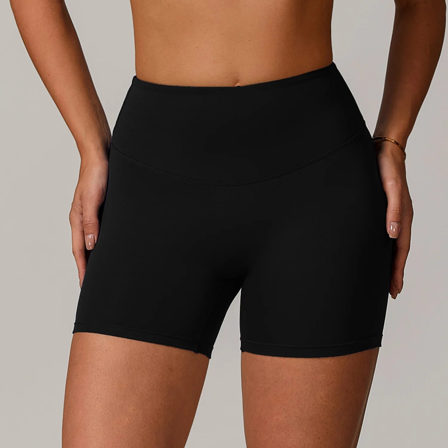 Black athletic shorts worn by a person on a neutral background