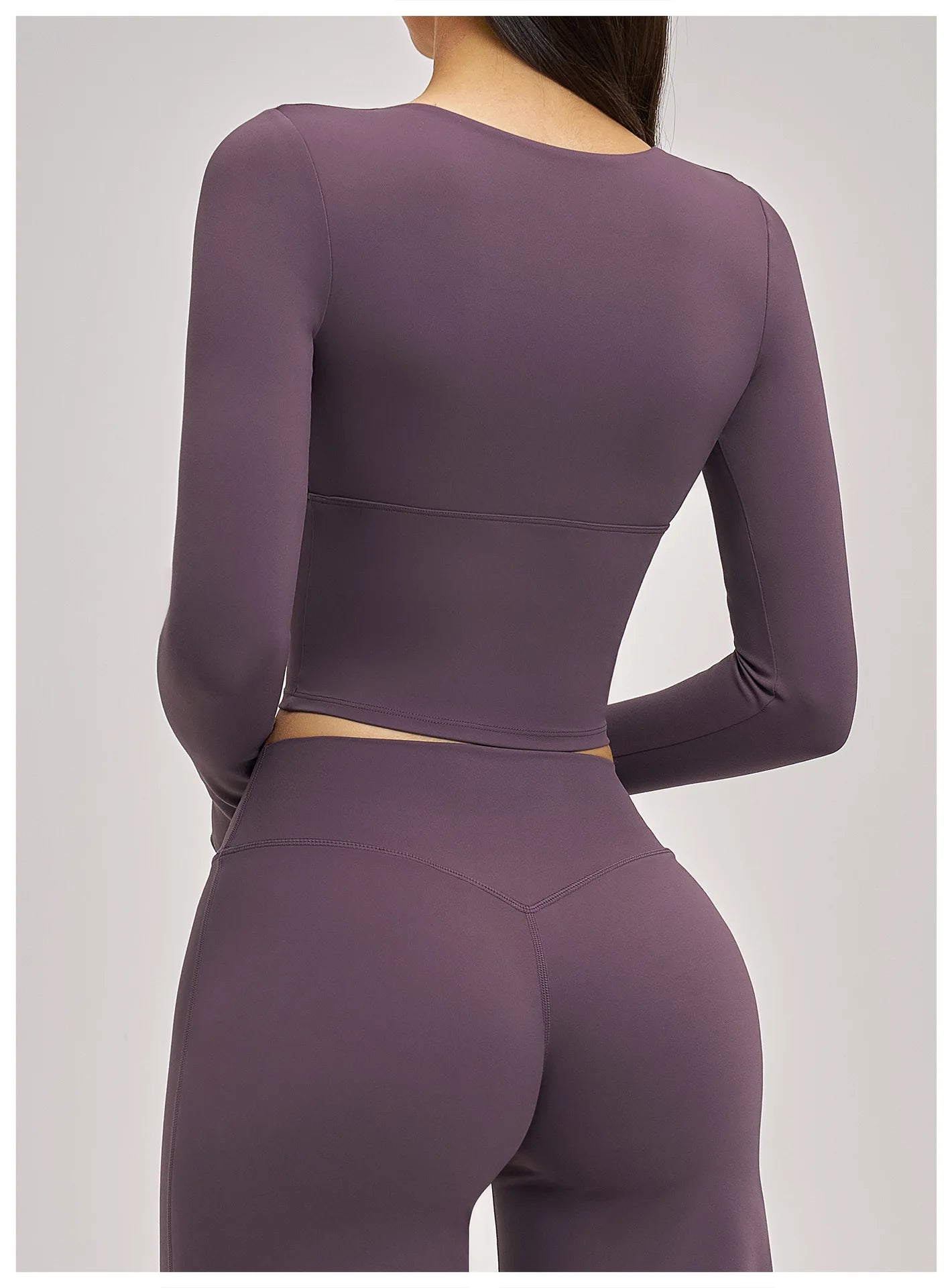Purple long-sleeve top and leggings set on a gray background