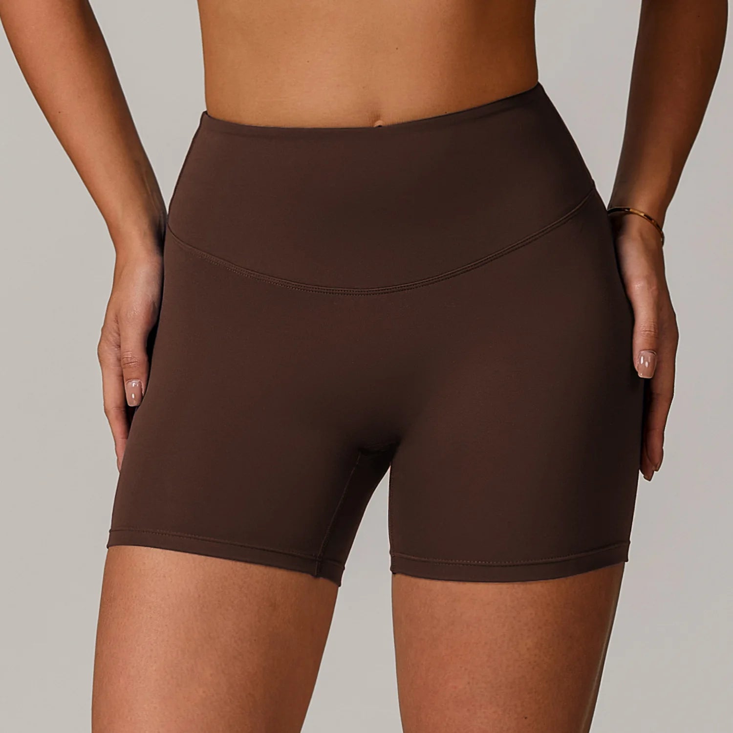 Brown athletic shorts worn by a person on a neutral background