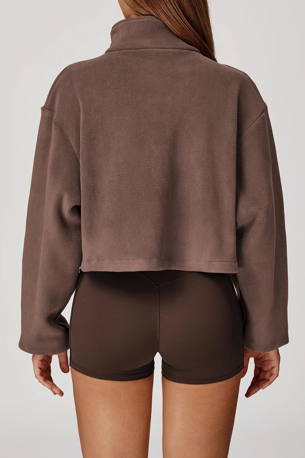 Brown jacket and shorts worn by a person on a white background