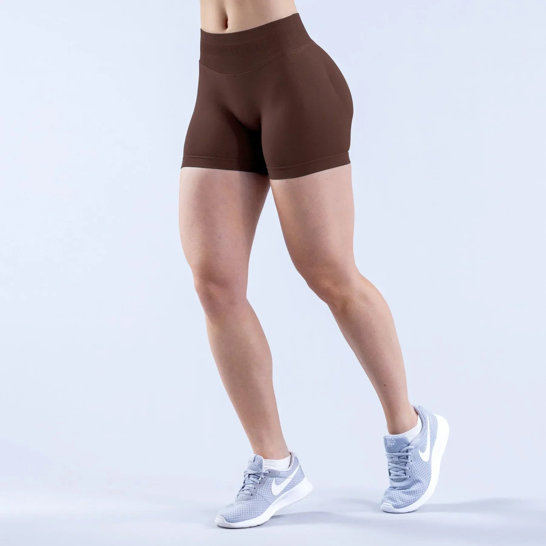 A pair of high-waisted,  espresso brown gym shorts with a seamless finish.
