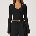 Black long-sleeve ballet wrap top and pants set on a plain background