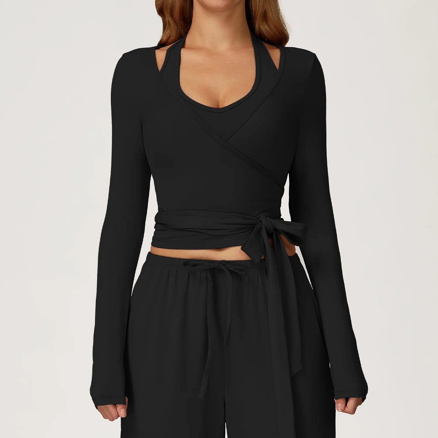 Black long-sleeve ballet wrap top and pants set on a plain background