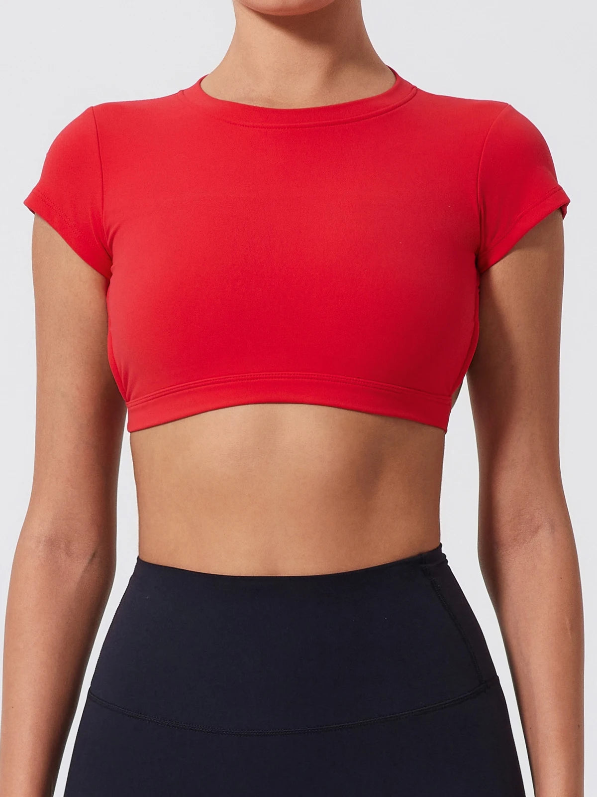 Red crop top worn by a person on a plain background