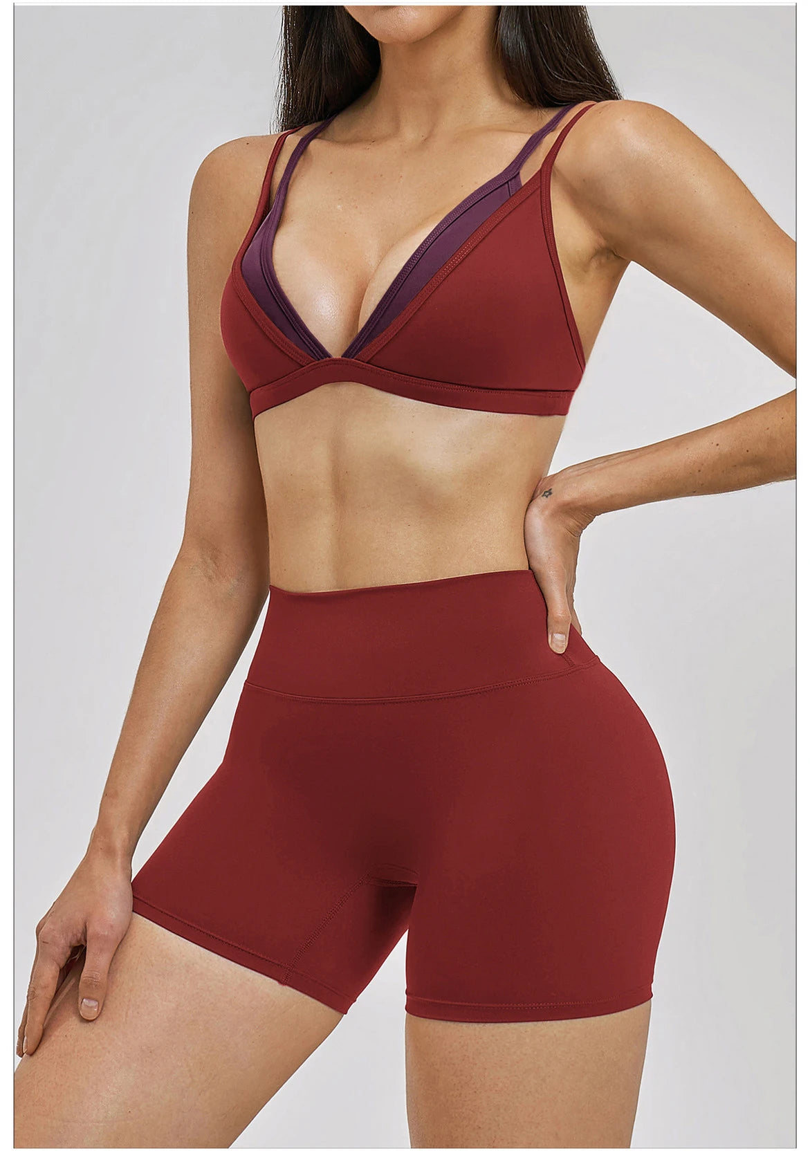 Woman wearing a red sports bra and shorts on a white background