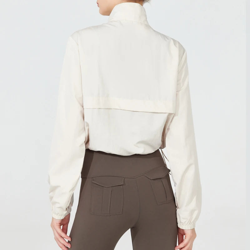 Person wearing a cream blouse and brown pants on a white background