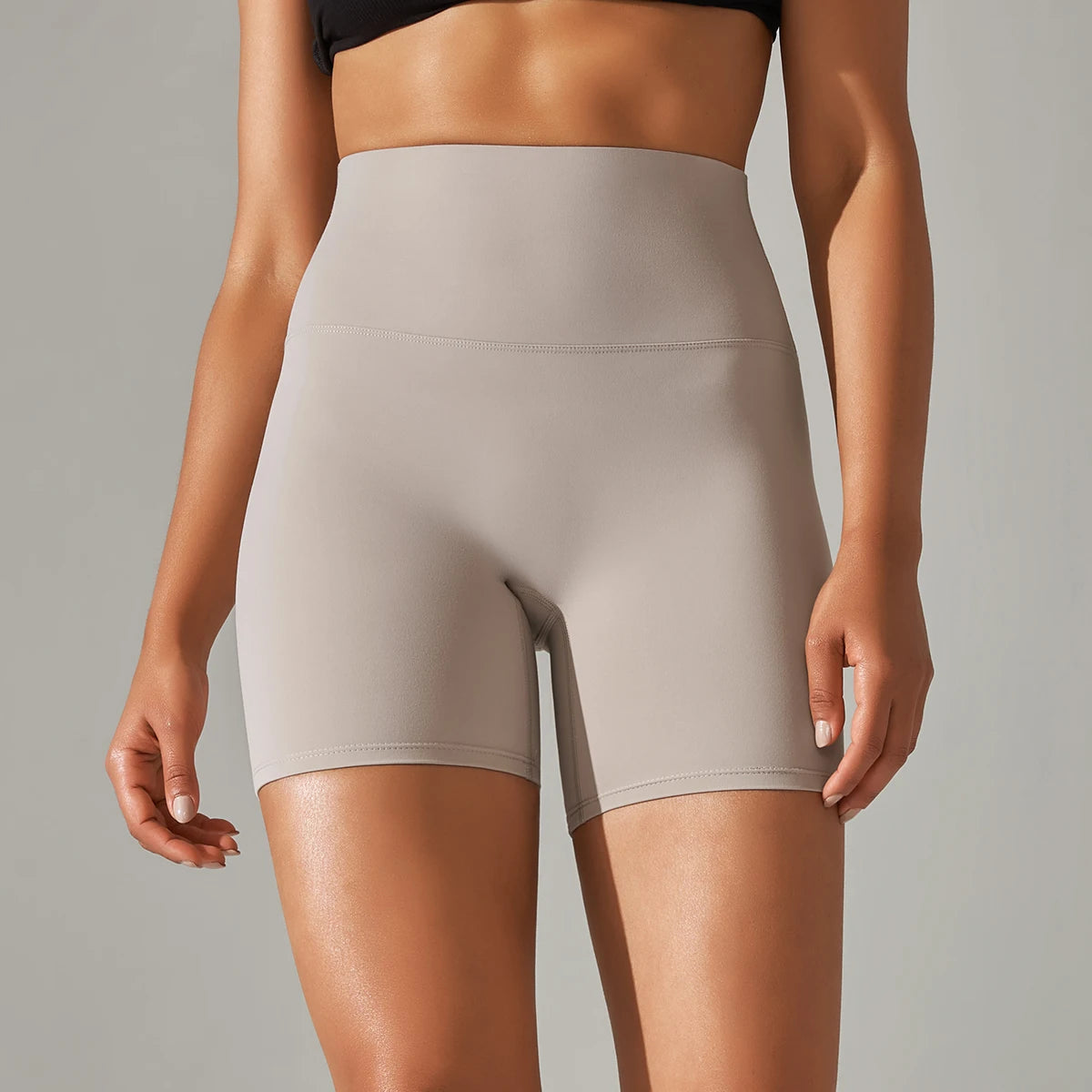 Stone high-waisted shorts worn by a person on a neutral background