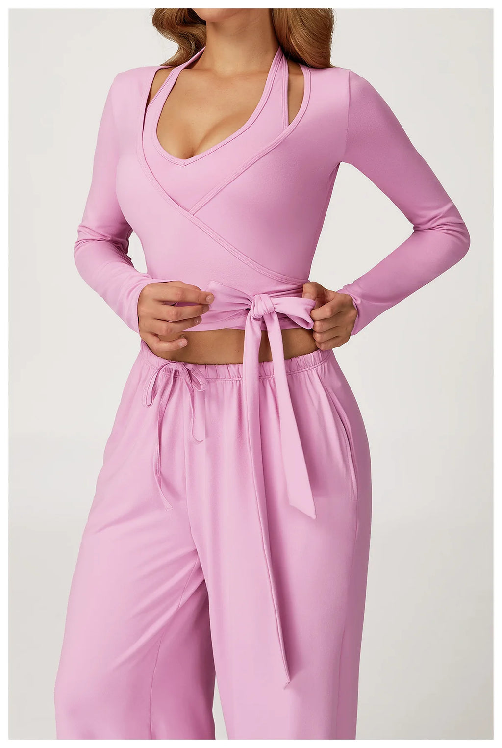 Pink long-sleeve ballet wrap top and pants set on a white background