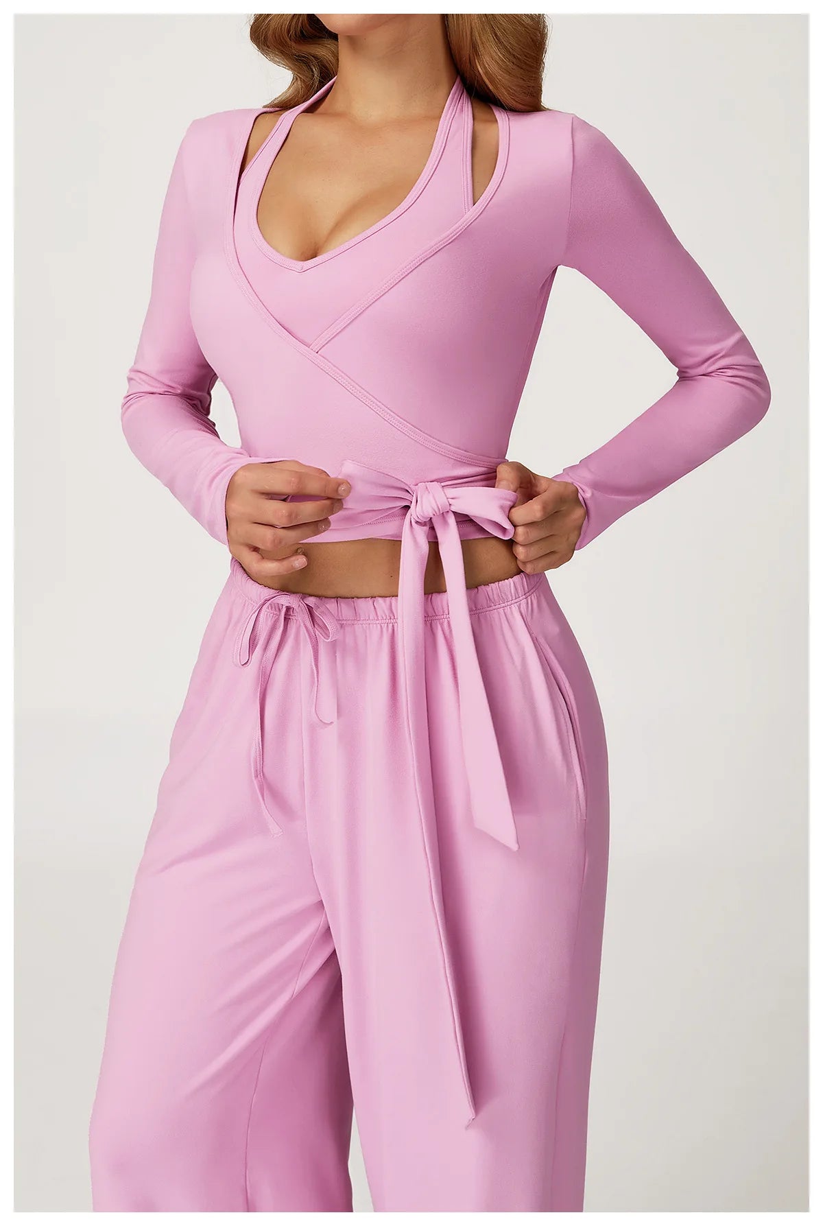 Pink long-sleeve ballet wrap top and pants set on a white background