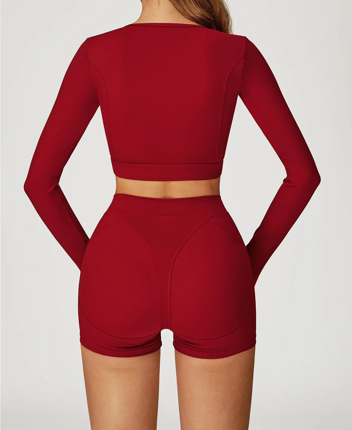 Red athletic outfit with long-sleeve top and shorts on a plain background