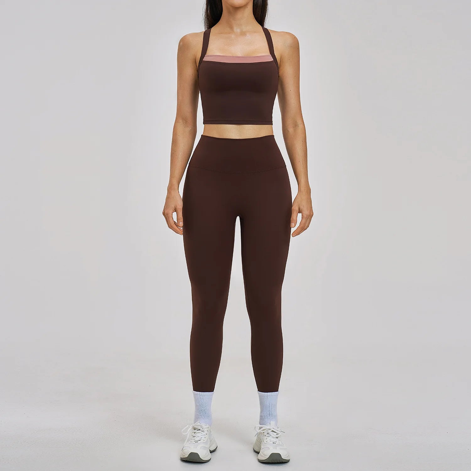 Person wearing a brown sports bra and leggings set on a gray background