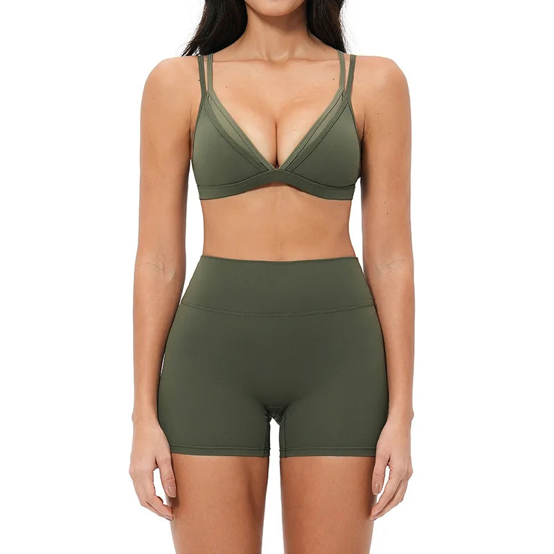 Person wearing a green sports bra and shorts set on a white background