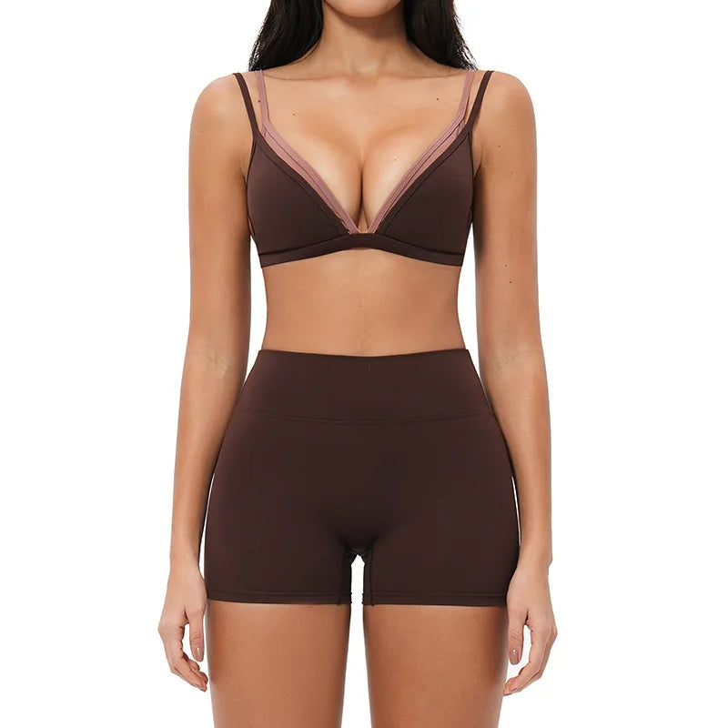 Woman wearing a brown bra and high-waisted shorts on a white background