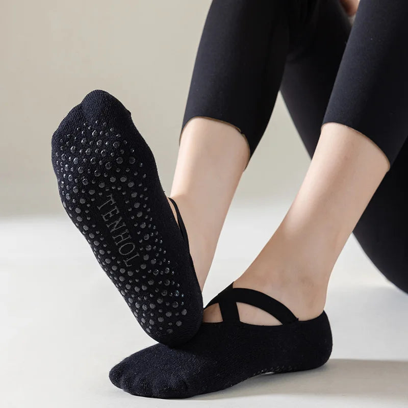 Black yoga socks with grip texture worn by a person on a light background