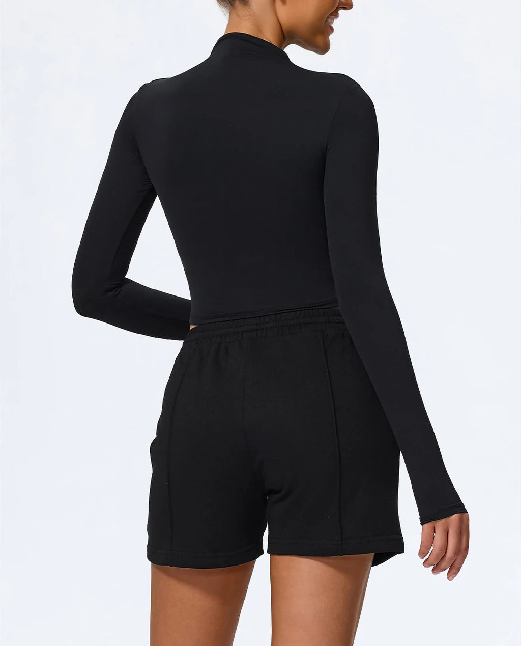 Black long-sleeve romper worn by a person on a white background