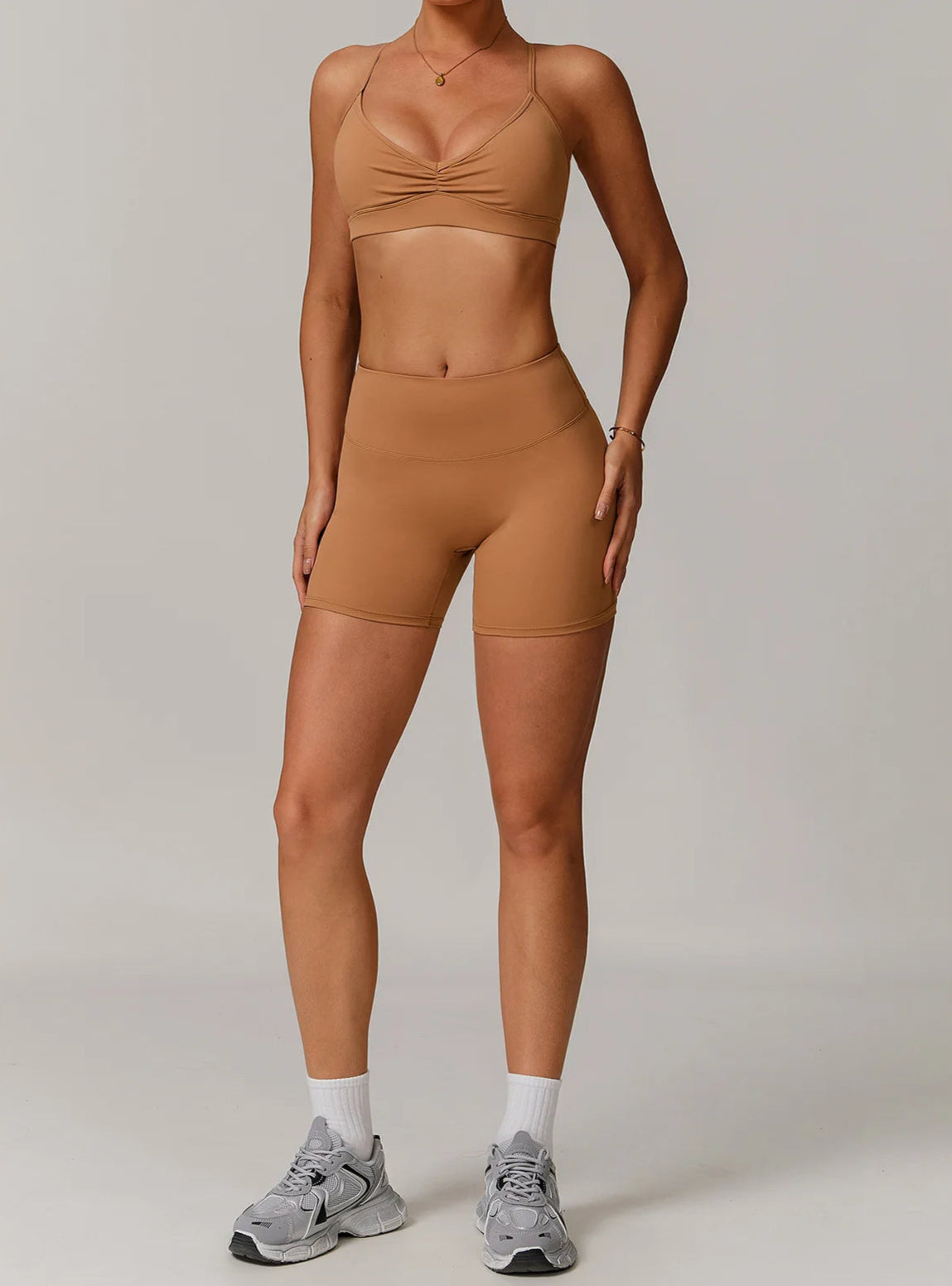 Person wearing a brown athletic outfit on a plain background