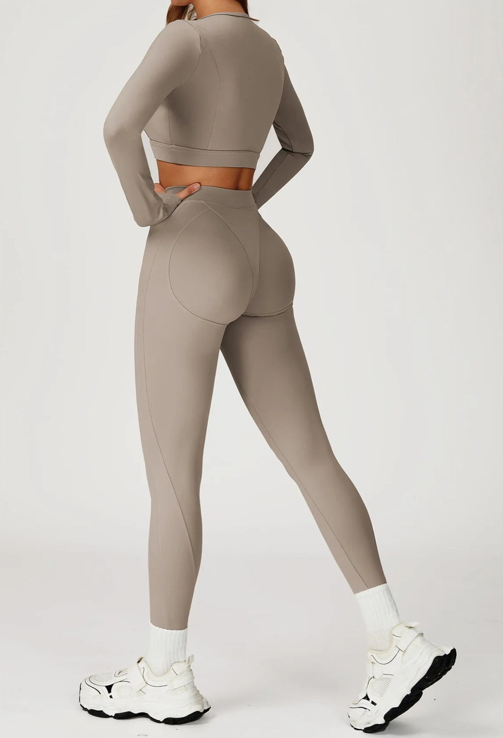 Person wearing a beige athletic outfit on a white background