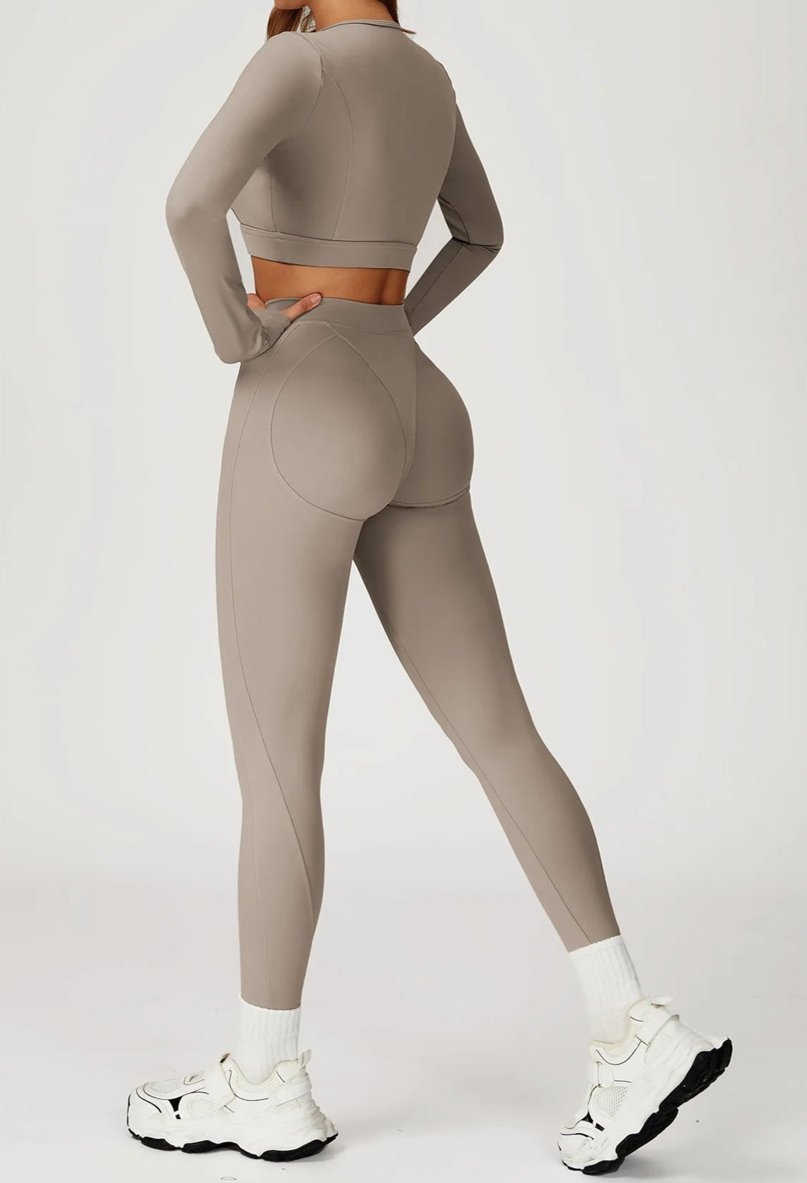 Person wearing a beige athletic outfit on a white background