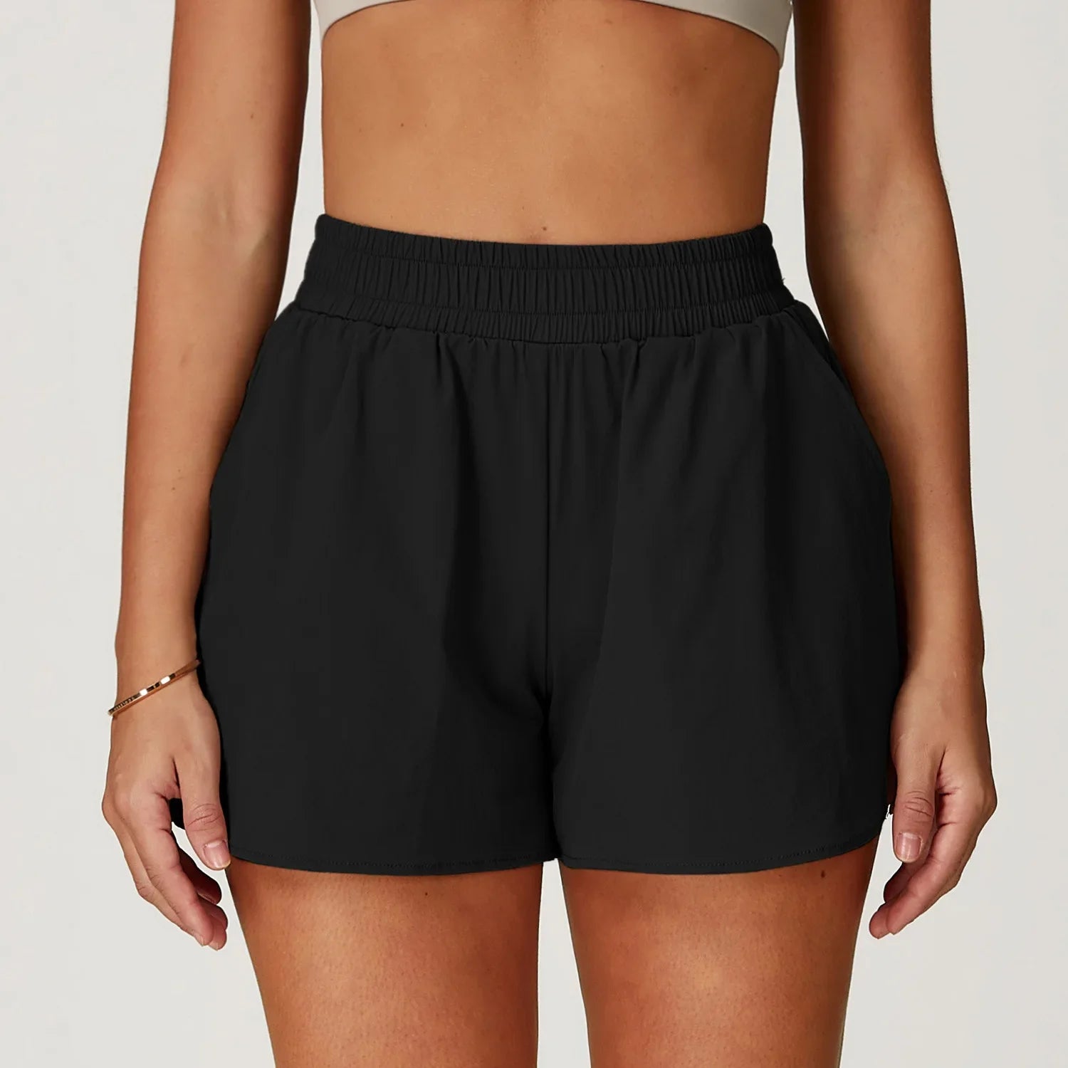 Person wearing black shorts on a plain background