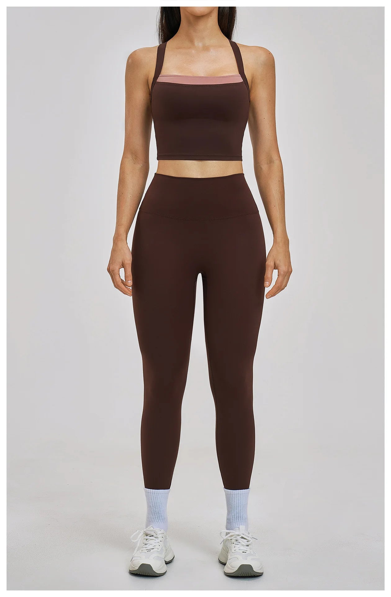Person wearing a brown sports bra and leggings set on a plain background