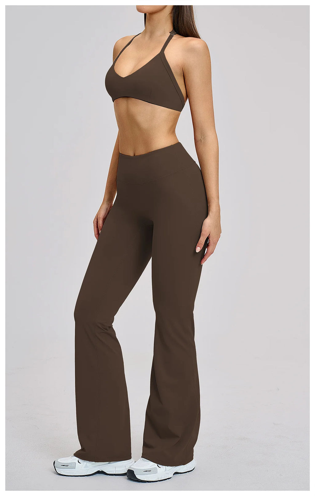 Woman wearing a brown sports bra and leggings set on a light gray background