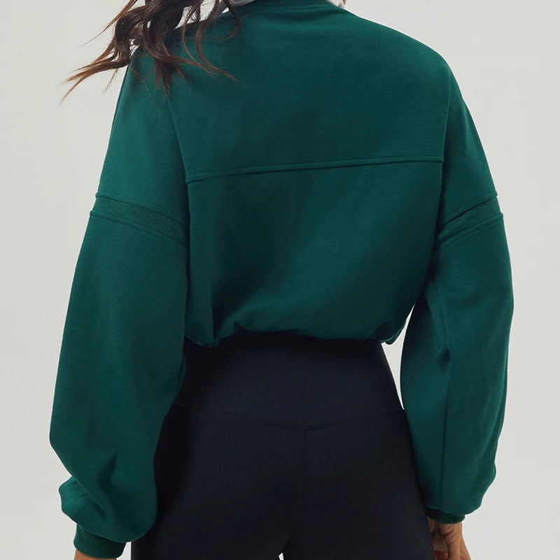 Green sweatshirt worn by a person on a plain background