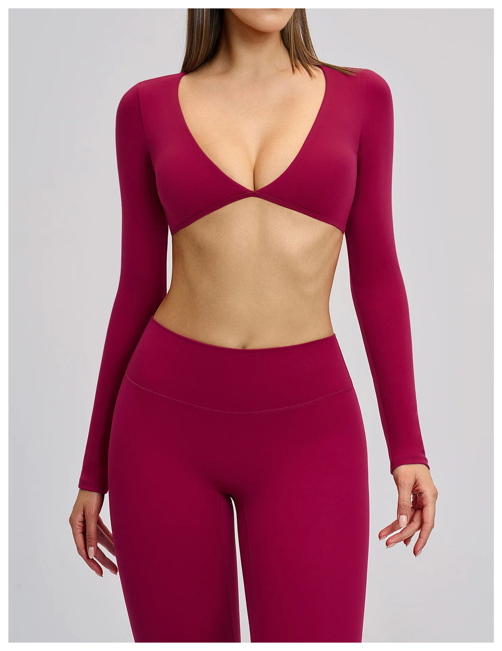 Person wearing a burgundy long-sleeve top and leggings on a plain background