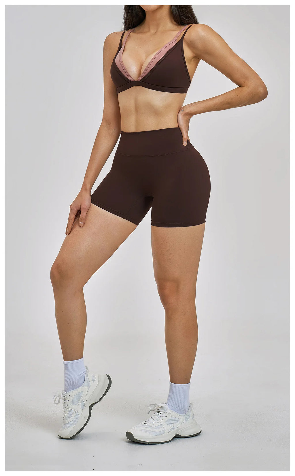 Person wearing a brown sports bra and shorts set on a plain background