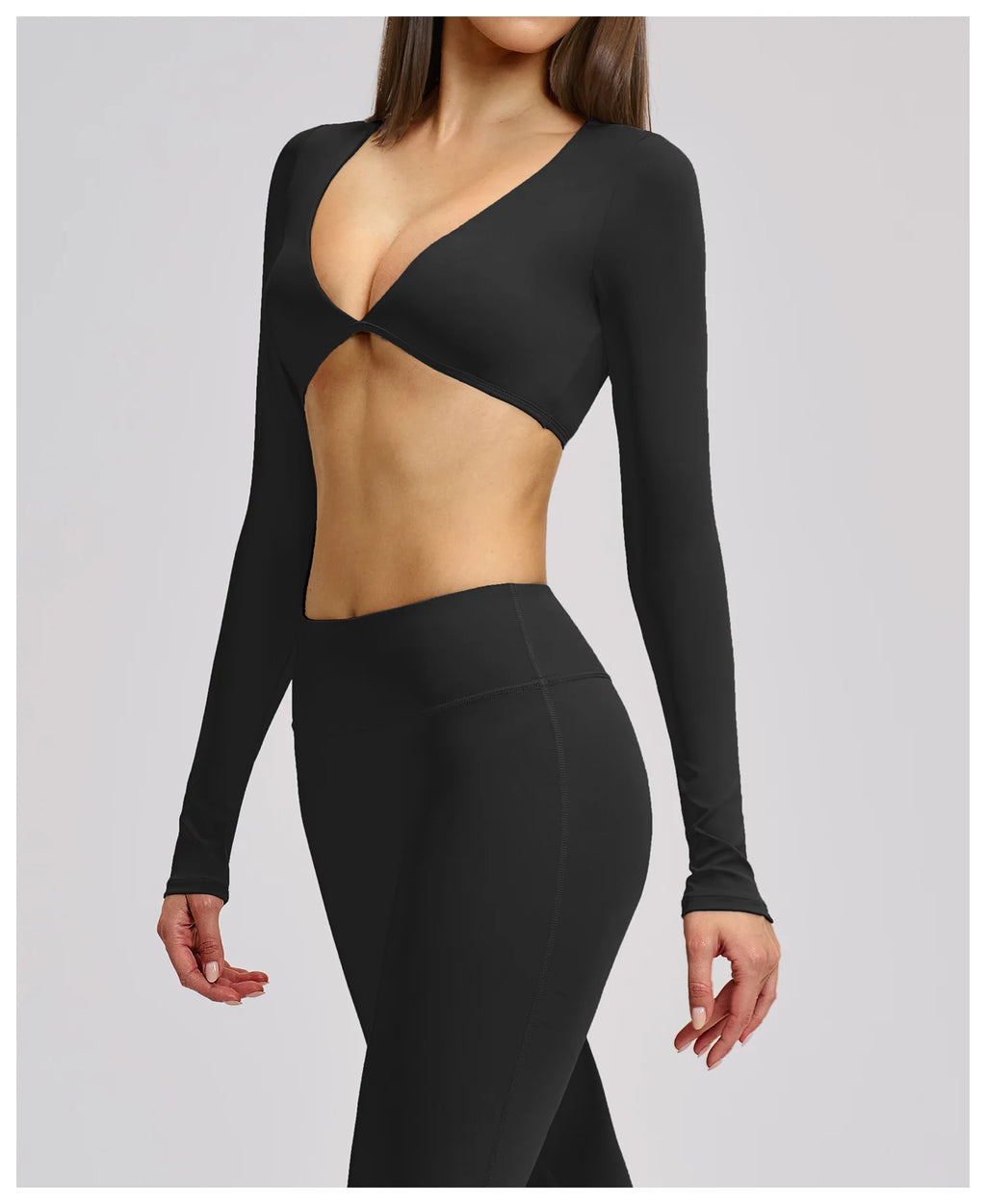 Black long-sleeve top with cut-out design on a plain background