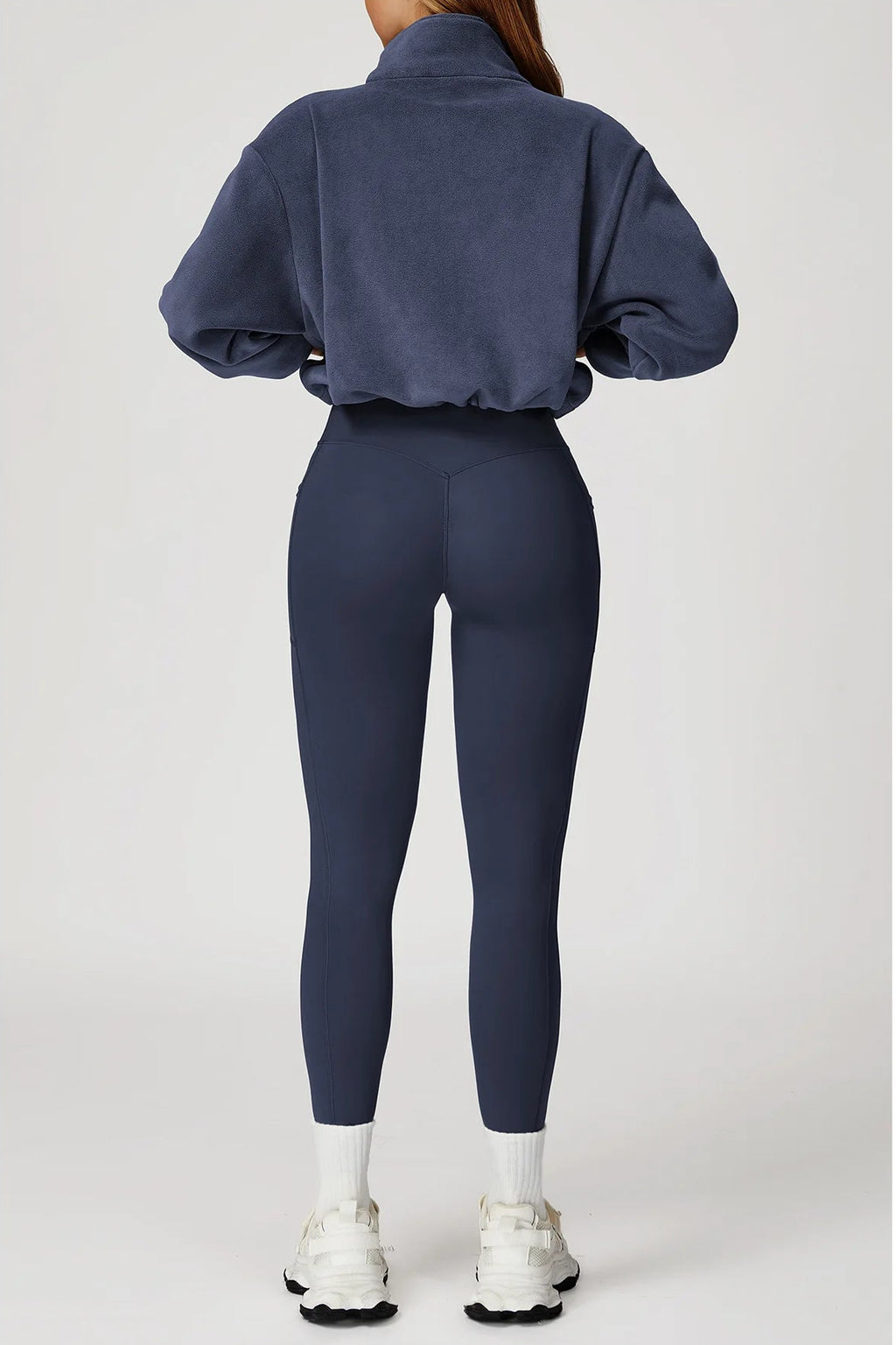 Person wearing a navy blue tracksuit on a white background