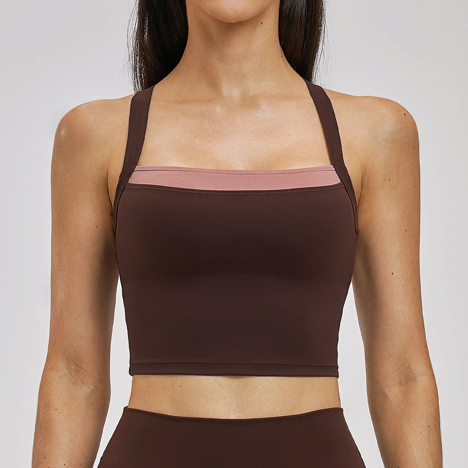 Brown sports bra worn by a person on a plain background