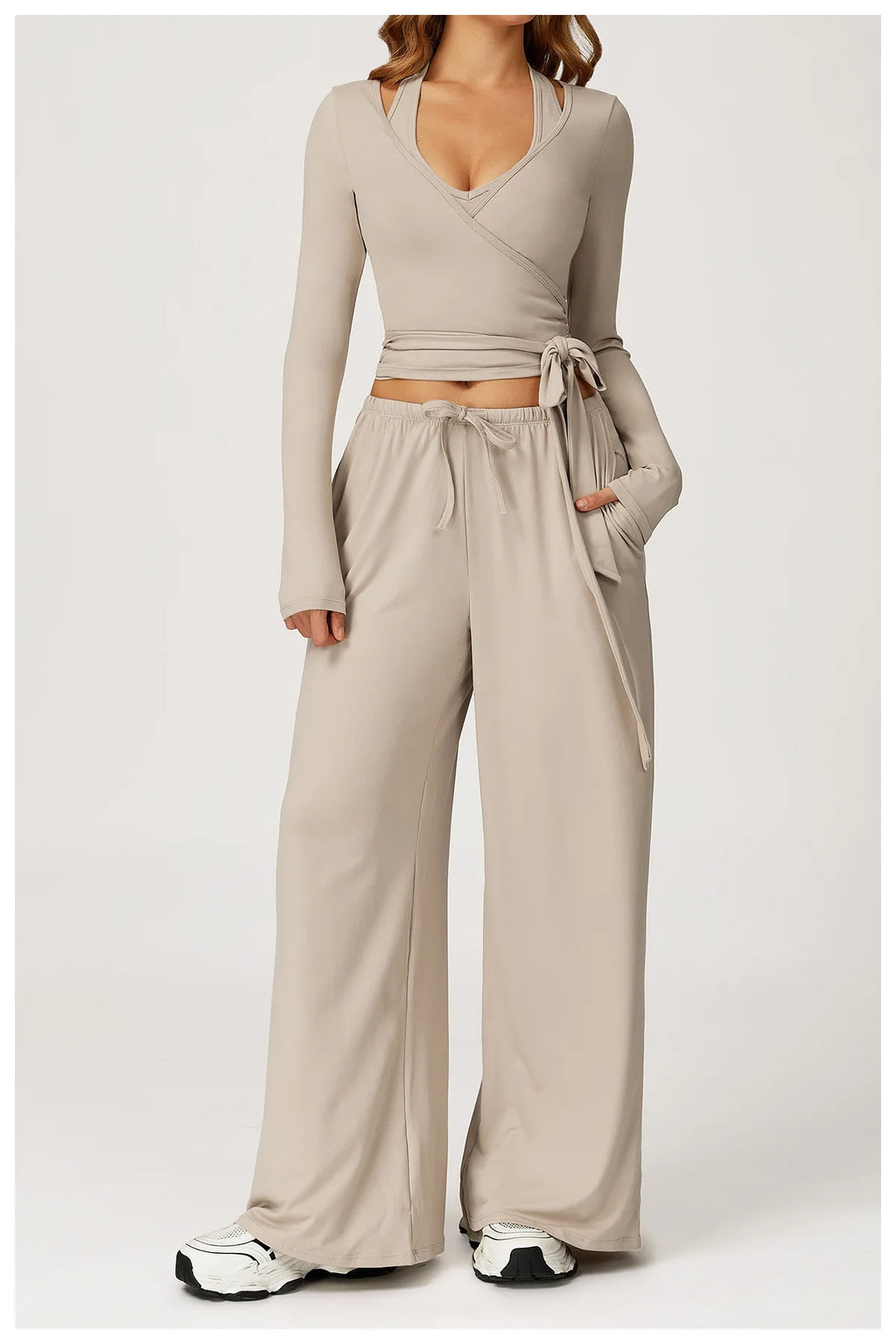 Beige long-sleeve ballet wrap top and wide-leg pants set on a white background