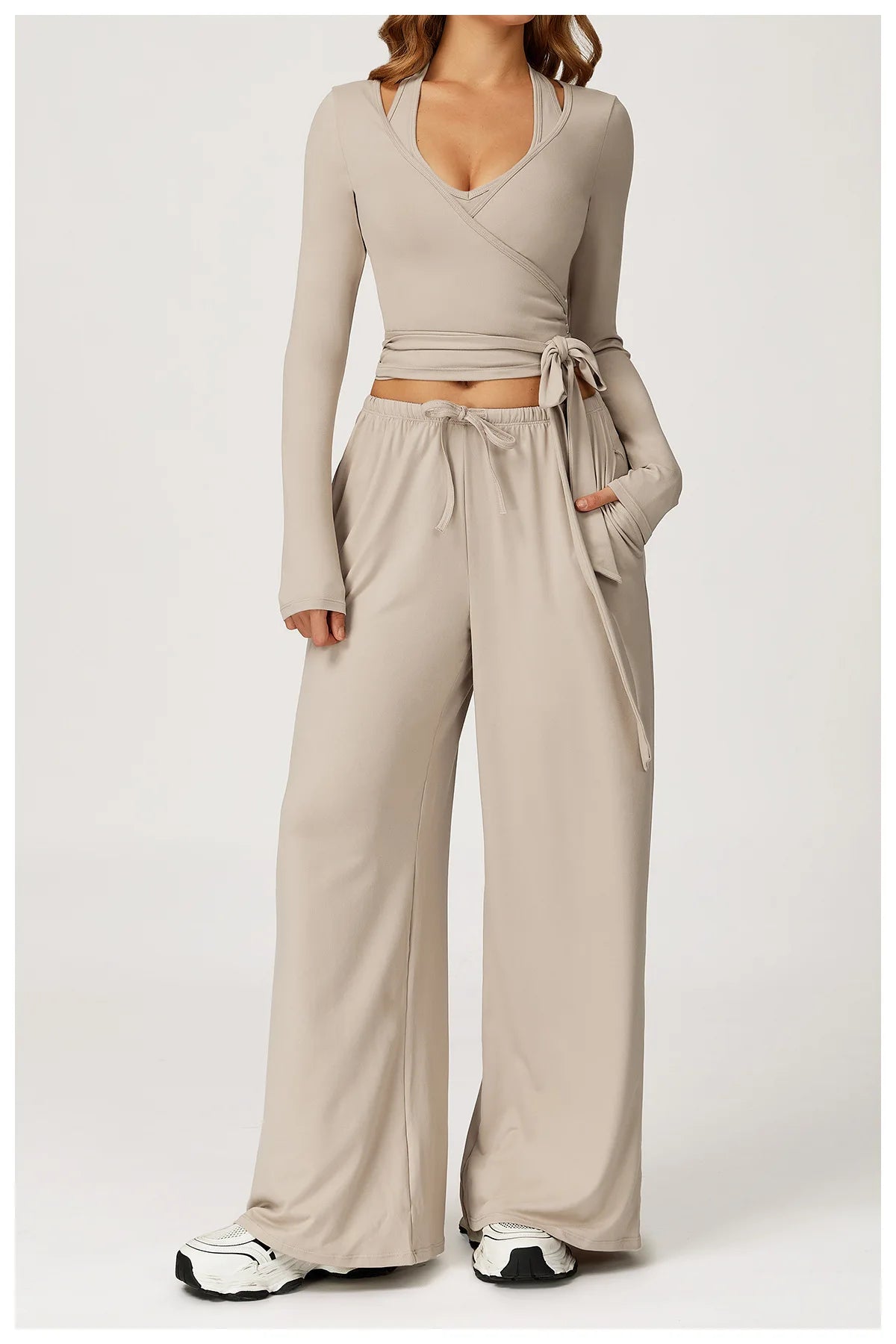 Beige long-sleeve ballet wrap top and wide-leg pants set on a white background